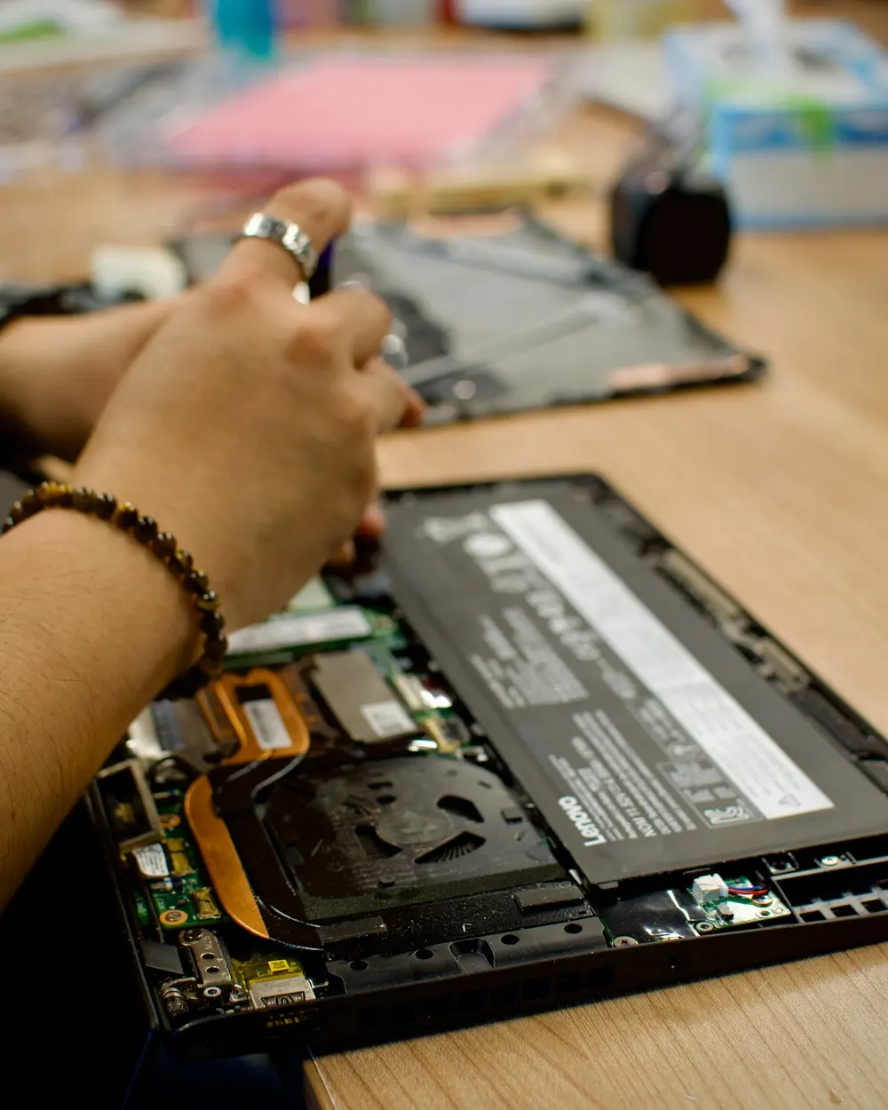 A UKEL technician repairing the inside of a laptop