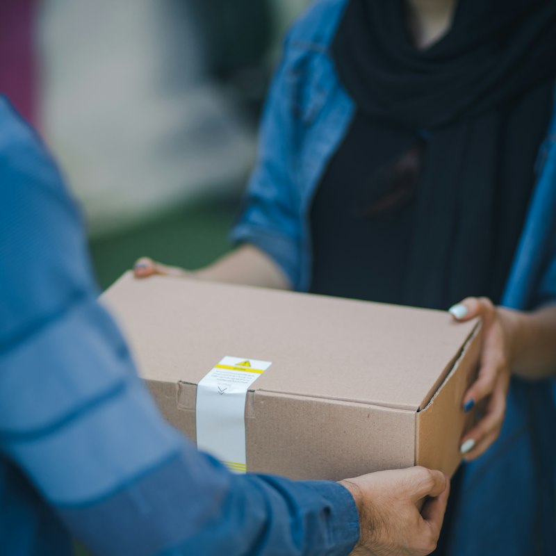 Courier handing over a device package at pickup
