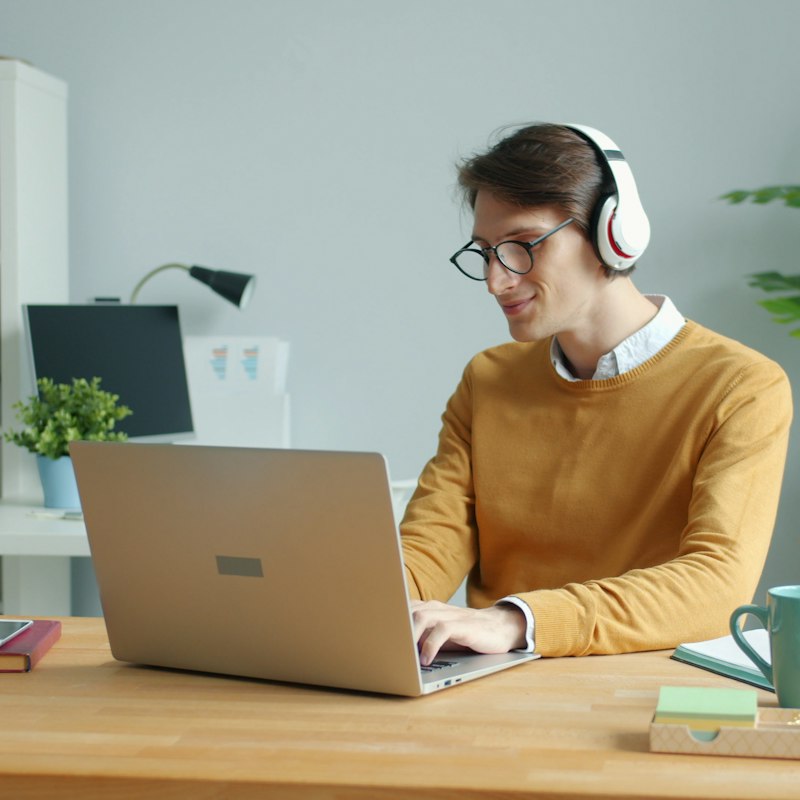 Support technician on a headset working remotely on a laptop